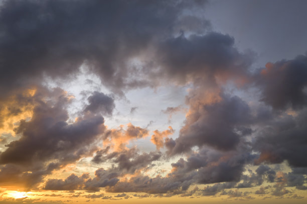 夕阳在傍晚的天空上照亮了彩色的云。日落时多变的云景天气图片下载