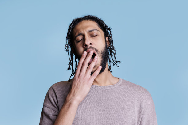 疲惫的阿拉伯人打哈欠，同时用手捂住嘴图片下载