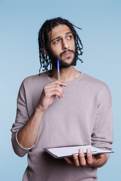 困惑的阿拉伯人思考时，检查剪贴板上的计划图片下载