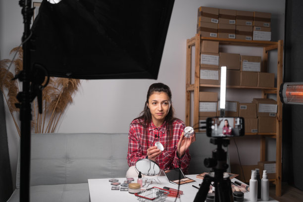 美妆网红在家用相机直播，推广化妆品，复制空间。女性的业务图片下载