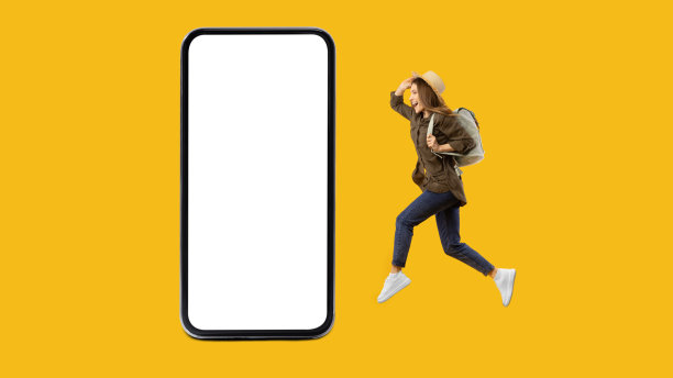 女性旅行者在黄色背景的巨大智能手机附近跳跃图片下载