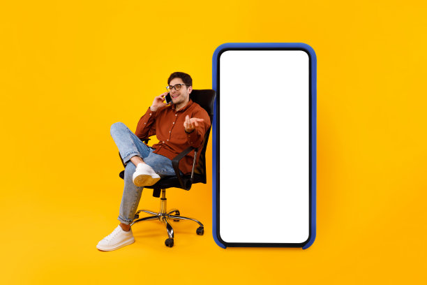 商人在大智能手机屏幕旁打电话，黄色背景图片下载