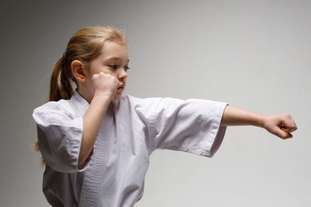 空手道拳，一个小孩穿着和服在白色背景上训练。图片下载