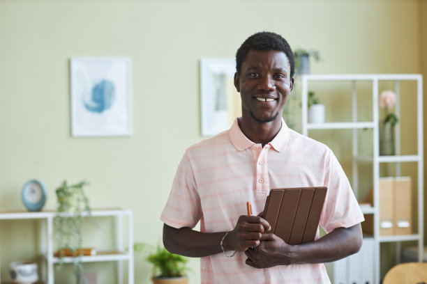 黑人男子微笑着站在办公室拿着平板电脑图片下载