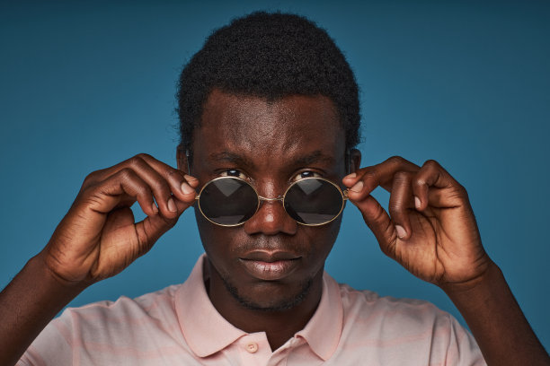 近距离的黑人男子戴着圆形太阳镜看着相机图片下载