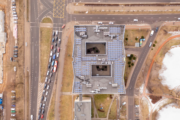 在多云的春天，无人机拍摄了交通堵塞的街道，办公室屋顶和太阳能电池板。图片下载