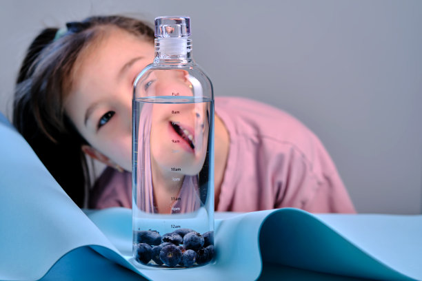 小女孩看着一瓶纯净水。图片下载