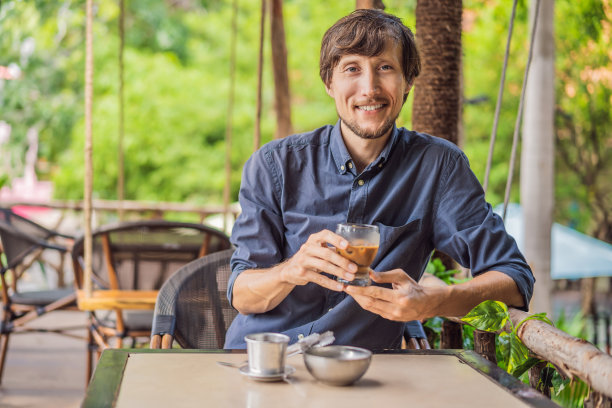 白人男子和传统滴煮越南咖啡从phin过滤器图片下载