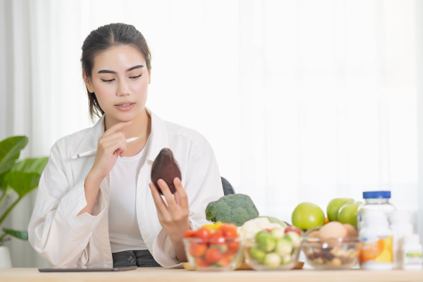 快乐的女性专业营养健康的包围着各种新鲜水果和蔬菜工作的数字平板电脑和微笑。正确的营养饮食观念，保健饮食。图片下载