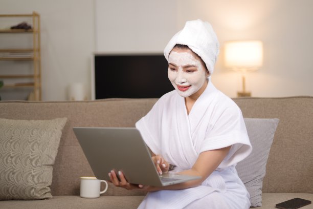 美丽的亚洲女人在度假时在家里使用化妆品和护肤品。图片下载