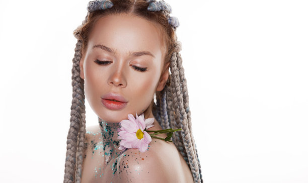 美丽的肖像可爱的年轻女子与健康的皮肤和粉红色的花附近的脸和闪闪发光的她的脸，脖子和肩膀在白色的背景图片下载