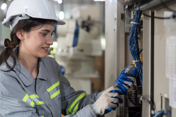 女电工在工厂检查、修理、维护操作电气系统。女电气工程师负责生产线的电气系统操作图片下载