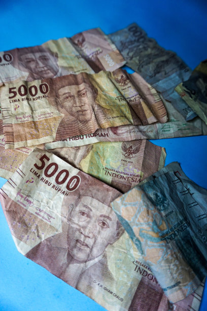 印尼盾货币对象，标记和杯子在蓝色背景的股票照片图片下载