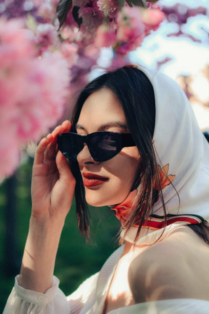 年轻漂亮时髦的女人戴着太阳镜和围巾的特写肖像。广告服装专卖店及配饰。股票与图片下载