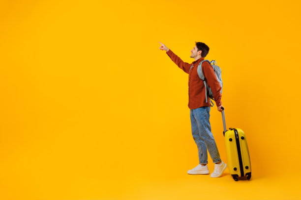 一名游客拿着行李箱站在一旁，用手指指着对方，黄色背景图片下载