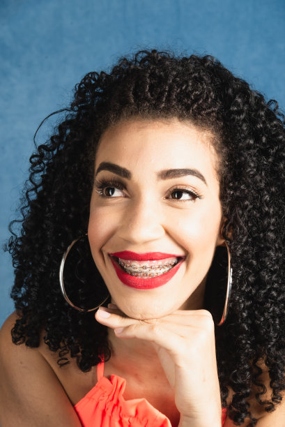 美丽的年轻女子的特写肖像，手放在下巴上图片下载