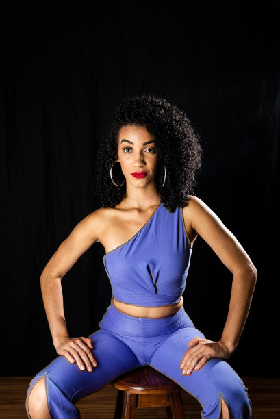 穿着蓝色衣服的年轻女子坐在木凳上。图片下载