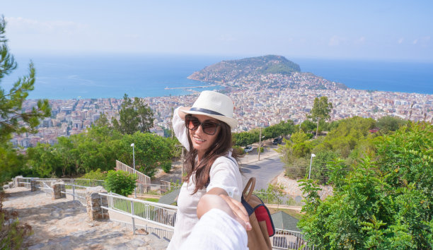 跟我去……女孩牵着摄影师的手，看着镜头，旅行，发现新的国家图片下载