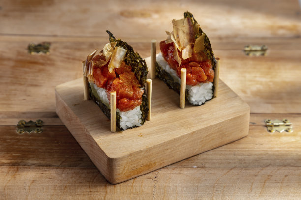 在木桌上的木架上，打开卷，里面有紫菜、米饭、鱼片和洋葱图片下载