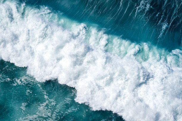 从高空俯瞰，见证海洋自然力量的原始力量的后果，巨大的海浪撞击并搅动着白色的浪花和汹涌的能量，这是令人惊叹的鸟瞰图图片下载