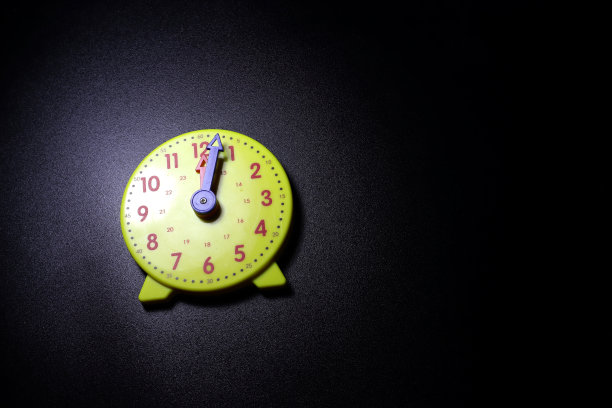 黑色背景上的黄色玩具钟图片下载