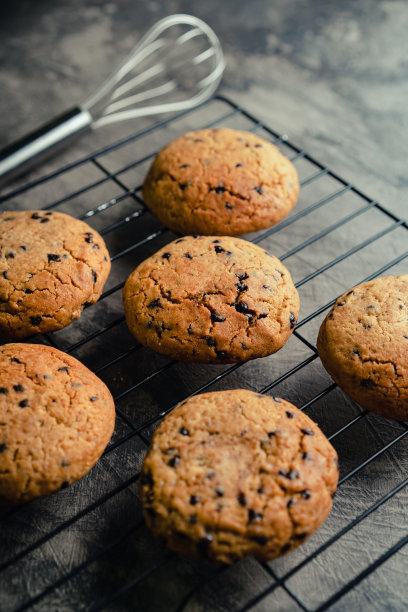 自制巧克力片饼干在黑色烘烤冷却盘和抽象背景图片下载