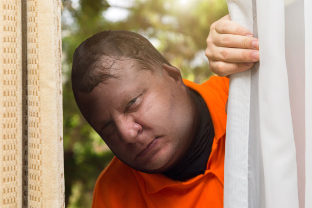 小偷偷偷地从别人家的窗户往外看，以便行窃图片下载