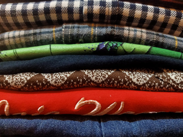 一堆熨好叠好的各式各样的衣服图片下载