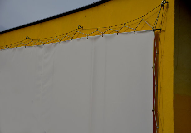 白色广告篷布安装后，用钢索扎入金属镀锌框架并锁孔。移动广告解决方案，易于更换内容，适合中期户外使用公司图片下载