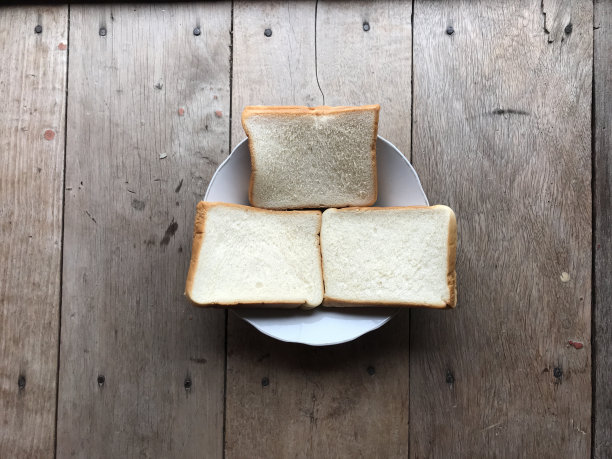 木质背景上的面包。乡村黑麦。木质纹理背景上的新鲜乡村传统面包。有硬皮面包的面包店。烘焙产品标签、设计等设计元素图片下载
