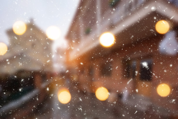 美丽的冬季模糊的第比利斯城市背景与飘落的雪和散景灯图片下载