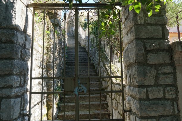 通往陡峭楼梯的旧金属入口或带门锁的大门。图片下载