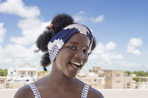 开朗的女孩站在露台上，非洲发型和辫子，照片图片下载