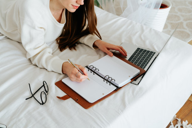 远程学习、在线教育和工作。女商人把要做的事写在笔记本上。剪短的自由职业女孩在家办公室用笔记本电脑。使用电脑和网上商店。复制空间空白模型图片下载