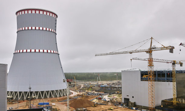 塔式起重机以冷却塔为背景。图片下载