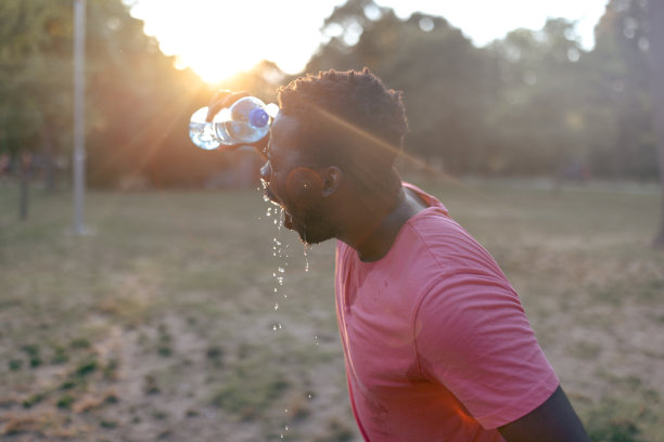 一个年轻的非洲运动员在公园里提神的照片。图片下载