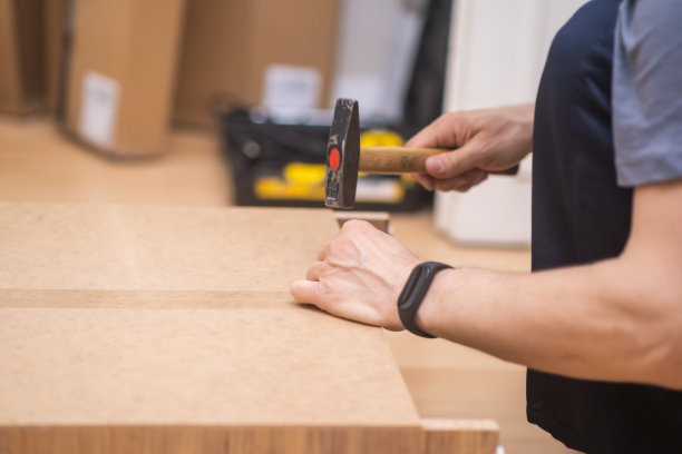 真正的勤杂工，近景摄影师用手精确而小心地组装家具。使用锤子图片下载