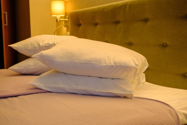 这张经典的双人床由实木制成，配有床头柜和照明设备，象征着健康的睡眠。结婚床上图片下载