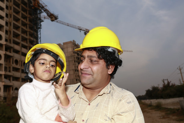 戴着安全帽的父女在工地附近的肖像图片下载
