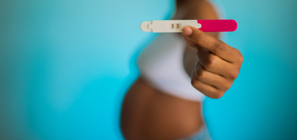 一名黑人孕妇和她的伴侣在户外展示婴儿拖鞋的照片图片下载