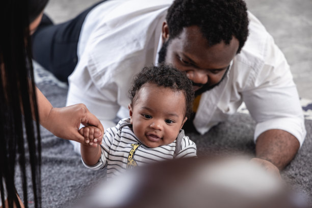 当一个蹒跚学步的孩子迈出他的第一步时，父亲的感人时刻图片下载