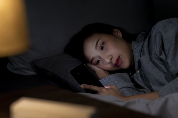 在床上使用智能手机的女性因失眠而无法入睡图片下载