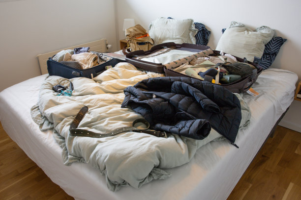 床上堆满了衣服和行李箱图片下载