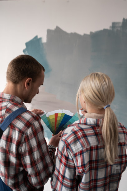 一对夫妇正在翻修他们的公寓，同时拿着调色板选择新油漆。维修、室内设计、装修及家居图片下载