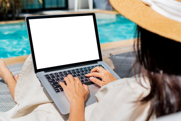 自由职业者使用笔记本电脑在游泳池附近远程工作。年轻的亚洲旅行者在暑假期间在电脑上工作。工作在任何地方，技术和生活方式的概念，复制空间图片下载