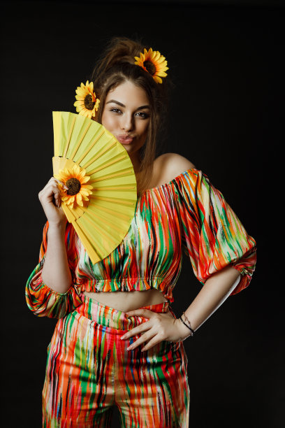 拿着一把黄色扇子，头发上插着向日葵的女人图片下载