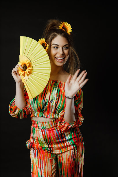 拿着一把黄色扇子的漂亮女人图片下载