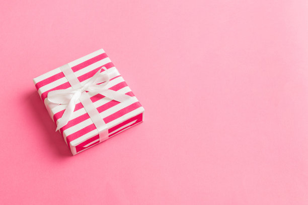 用彩纸包装的圣诞节或其他节日手工礼盒，彩色背景上有缎带。礼品盒，彩色桌子上的礼品装饰，顶部视图与复制空间图片下载