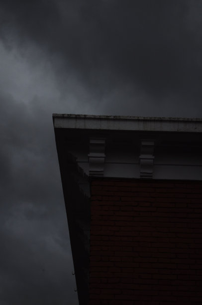 低角度拍摄一座被乌云包围的建筑物。图片下载