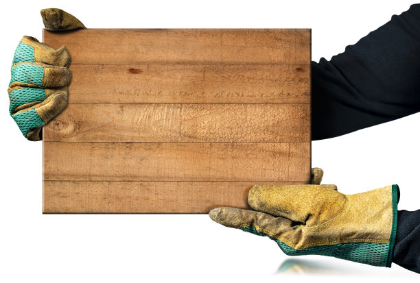 带着工作手套的木匠拿着一块棕色的木板图片下载